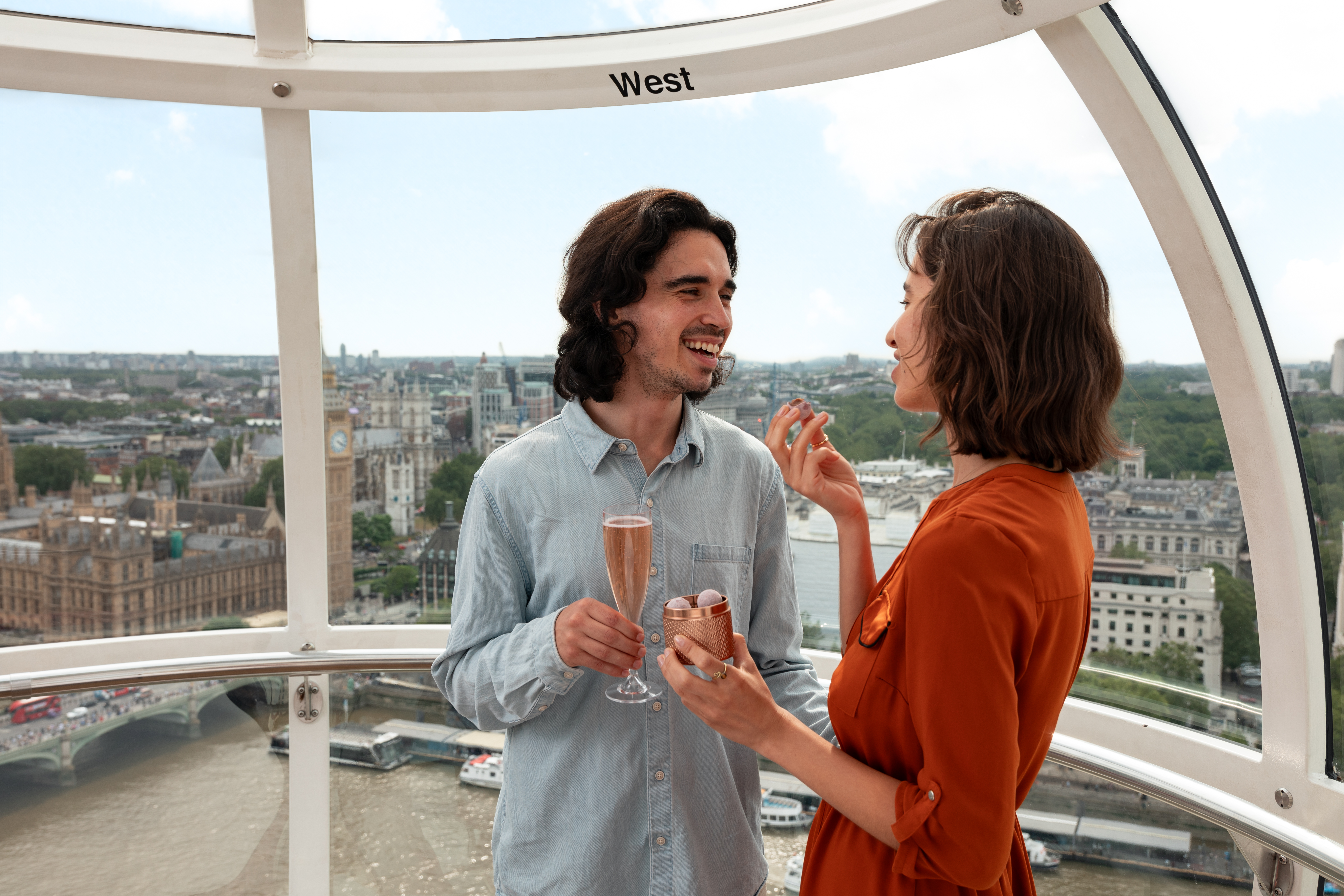 Couple enjoying champagne and chocolates while on the London Eye