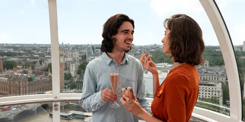 Couple enjoying champagne and chocolates while on the London Eye